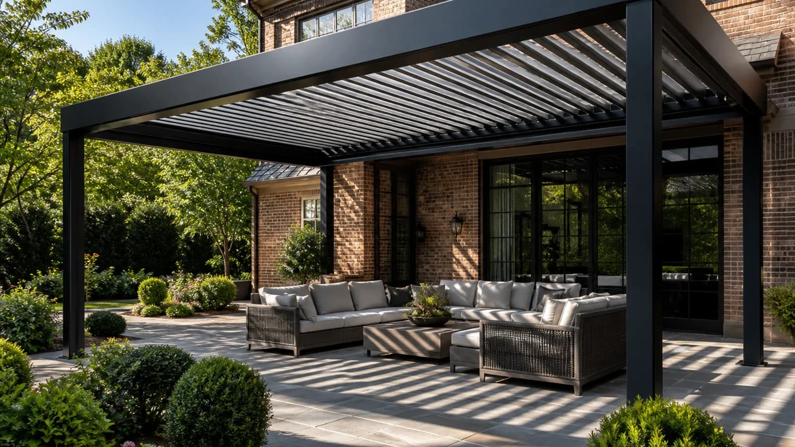 Dark aluminum louvered pergola casting adjustable bands of shade across a Charlotte patio