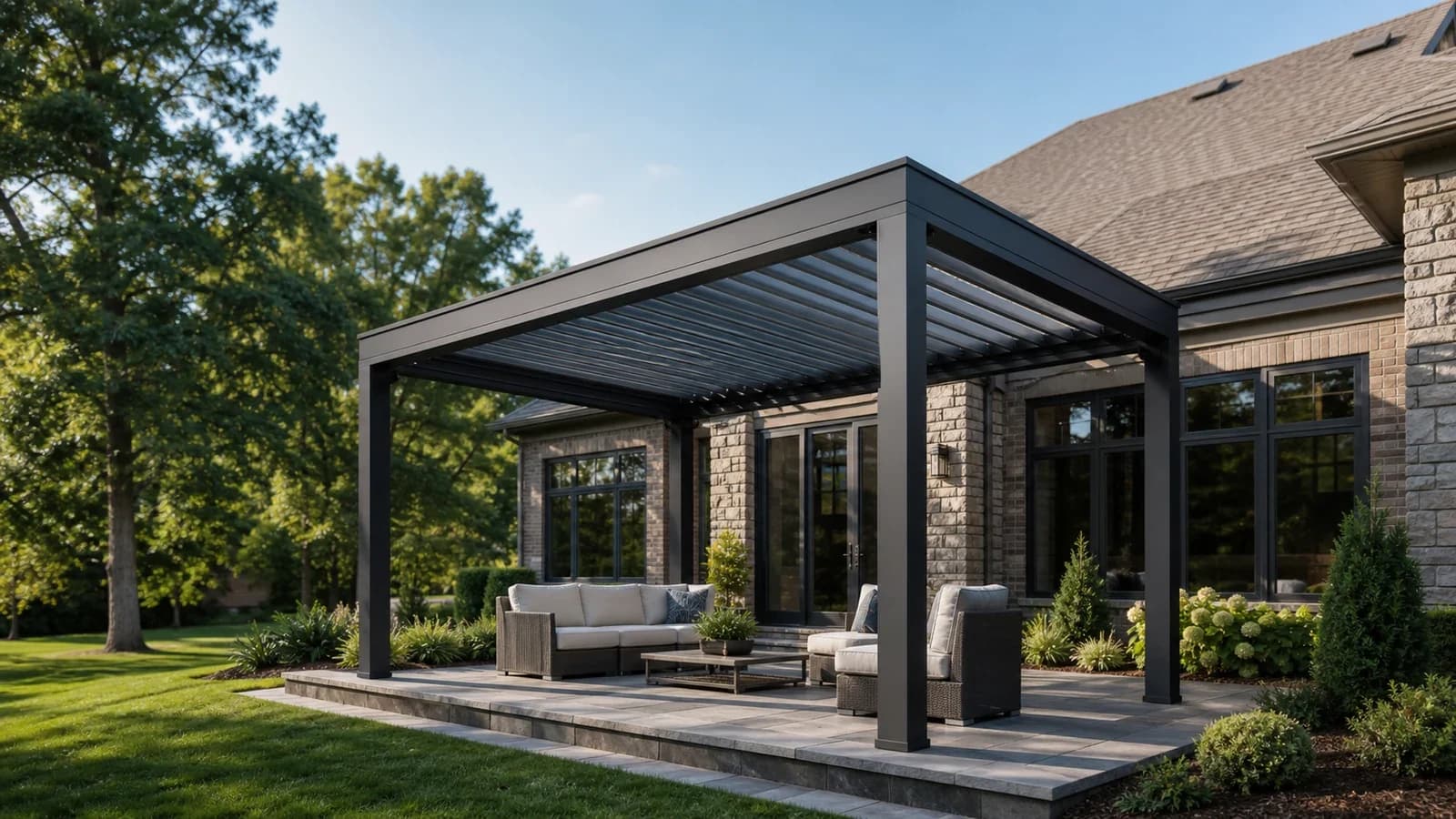 Freestanding dark aluminum louvered pergola on a landscaped backyard patio beside a Charlotte-area home