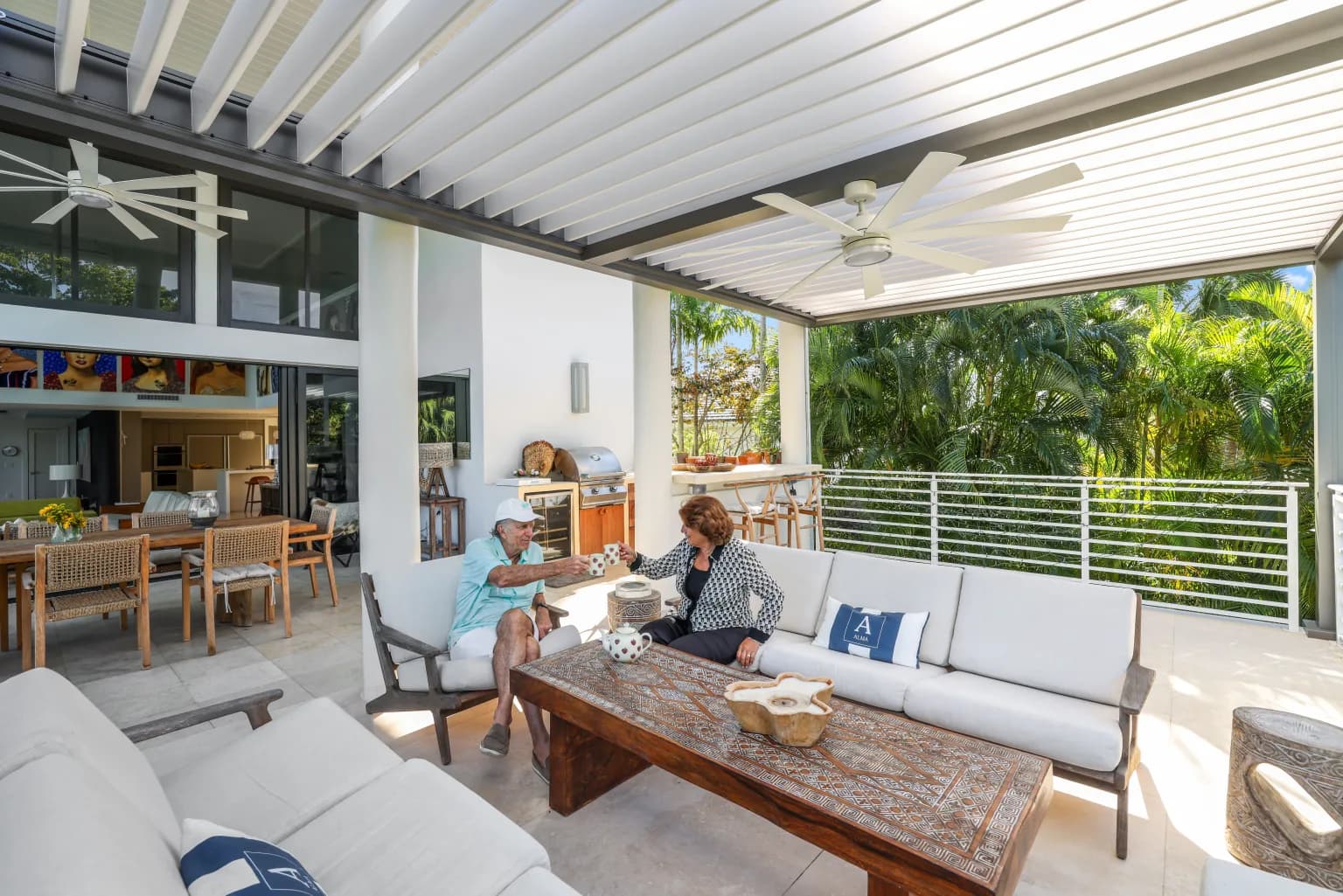 R-BLADE motorized louvered pergola with LED lighting beside a pool at dusk