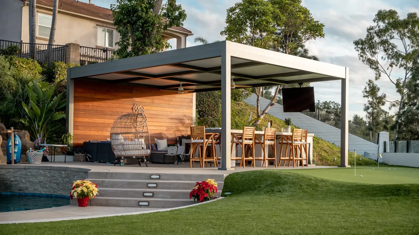 Two ceiling fans beneath a gray aluminum patio cover with fixed insulated roof panels