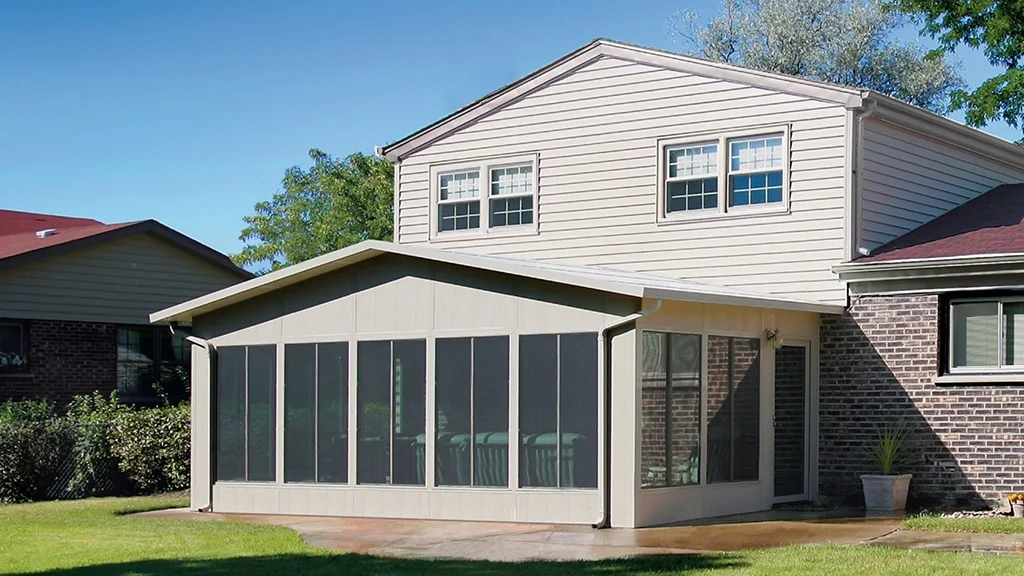 Attached screen room with dark insect-mesh panels and a solid roof beside a brick home